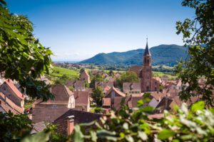 Typical french village with rooftops, church and hills in the background